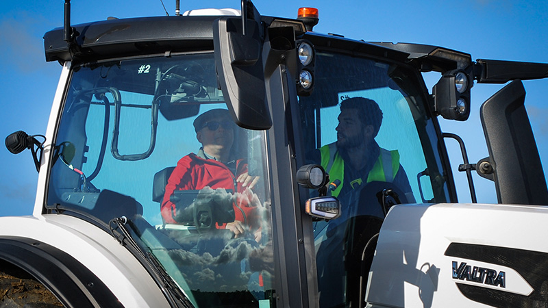 A Valtra product specialist demonstrates smart farming technology and provides a test drive to a Valtra customer